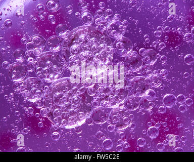 Molte bolle in un viola olio di miscela di liquido Foto Stock