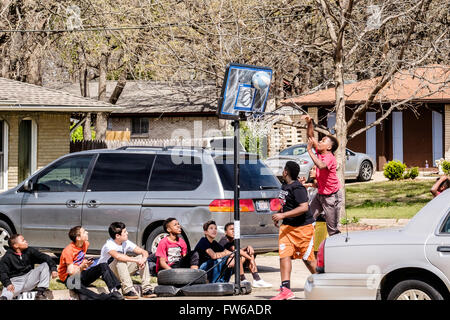 Teen e pre-teen boys raccogliere e giocare a basket su strada nella città di Oklahoma, Oklahoma, Stati Uniti d'America. Foto Stock