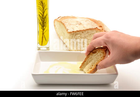 Donna di mano il pane di immersione in olio di oliva Foto Stock