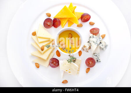 Piatto con quattro tipi di formaggi, uva Foto Stock