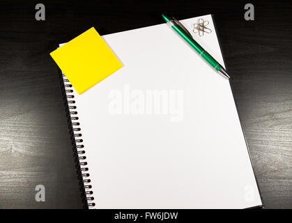 Notebook con carta bianca, colore sticky notes, penna e clip su un tavolo di legno Foto Stock