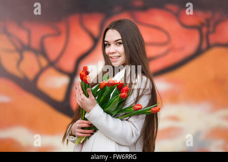 Giovane donna felice con bouquet di tulipani outdoor Foto Stock