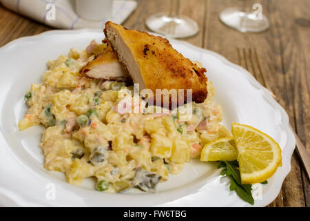 Tradizionale ceca Schnitzel con patate e insalata di verdure su tavola di legno Foto Stock