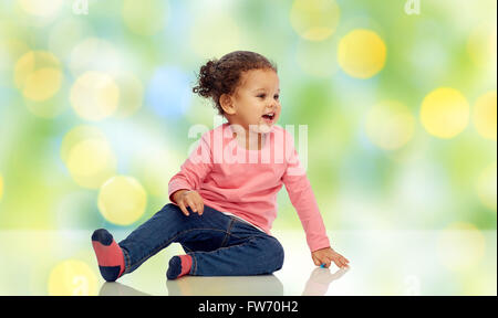 Sorridente bambina ragazza seduta sul pavimento Foto Stock