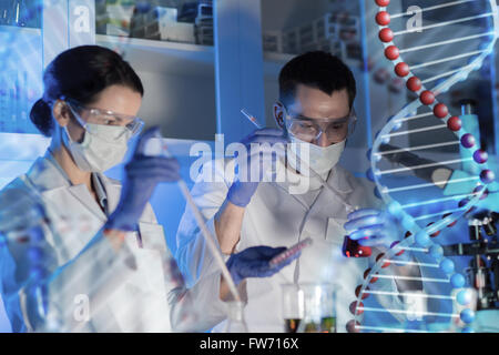 Gli scienziati con le pipette e le provette in laboratorio Foto Stock