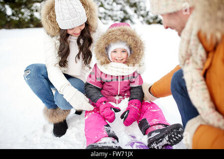 La famiglia felice con slitta passeggiate in inverno all'aperto Foto Stock