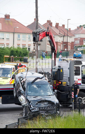 Sheffield, Regno Unito - 1 Luglio 2015: camion di recupero rimuove auto da suburban crash scena il 1 luglio a Hastilar Road South, Sheffield, Regno Unito Foto Stock