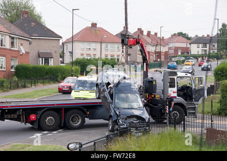 Sheffield, Regno Unito - 1 Luglio 2015: camion di recupero rimuove auto da suburban crash scena il 1 luglio a Hastilar Road South, Sheffield, Regno Unito Foto Stock
