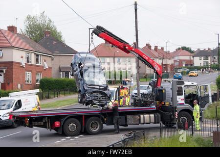 Sheffield, Regno Unito - 1 Luglio 2015: camion di recupero rimuove auto da suburban crash scena il 1 luglio a Hastilar Road South, Sheffield, Regno Unito Foto Stock