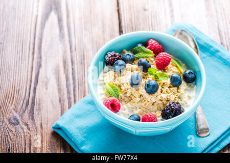 Gustosa e leggera dieta colazione di cereali con sumer frutta, il latte e il miele. Concetto di dieta e benessere. Foto Stock