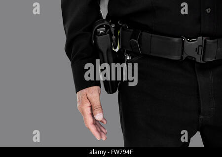 Uomo in uniforme che indossa una cintura con una pistola Foto Stock