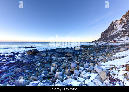 Spiaggia di Vikten nelle Isole Lofoten in Norvegia in inverno al tramonto. Foto Stock