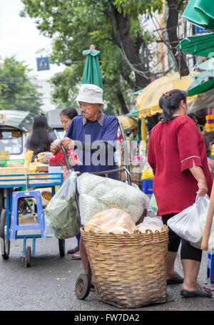 Venditore con un carrello sul mercato, Pak Khlong Talat freschi di mercato alimentare Foto Stock