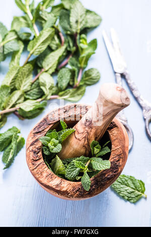 Di menta fresca in stile rustico in legno mortaio sul tavolo di legno Foto Stock