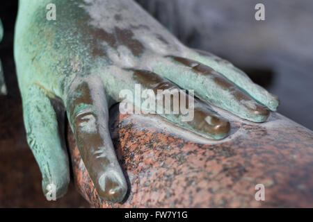 Mano di metallo di una antica statua in bronzo che stabilisce su Foto Stock