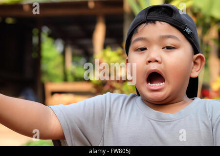 Ritratto di funny sbadigli boy -Asia,Thailandia bambini (messa a fuoco selettiva) Foto Stock