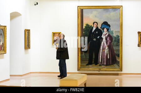 Oviedo, Spagna. Il 31 marzo, 2016. Un visitatore con la pittura ad olio "Fernando VII y Maria Cristina" (1832) di Luis de la Cruz y Rios dietro di lui durante la riapertura del Museo di Belle Arti di Asturias il Marzo 31, 2016 a Oviedo, Spagna. Credito: David Gato/Alamy Live News Foto Stock