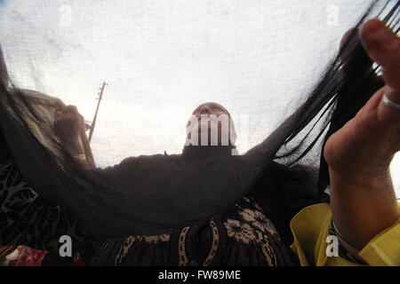 Srinagar, India. 1 Aprile, 2016. Un musulmano del Kashmir donna prega come un sacerdote di testa (non in foto) visualizza la reliquia, credeva di essere i capelli da la barba del Profeta Mohammad (saw), durante speciali preghiere alla morte anniversario di Abu Bakr Siddiq (RA), il primo califfo dell Islam, al Santuario Hazratbal nella periferia di Srinagar la capitale estiva della controllata indiana del Kashmir. © Faisal Khan/Pacific Press/Alamy Live News Foto Stock