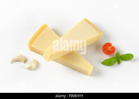 Due spicchi di parmigiano fresco e guarnire su sfondo bianco Foto Stock