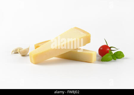 Due spicchi di parmigiano fresco e guarnire su sfondo bianco Foto Stock