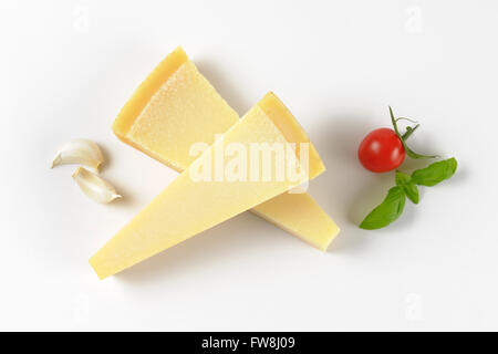 Due spicchi di parmigiano fresco e guarnire su sfondo bianco Foto Stock