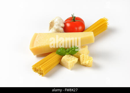 Parmigiano fresco, verdure guarnire e fascio di materie spaghetti su sfondo bianco Foto Stock