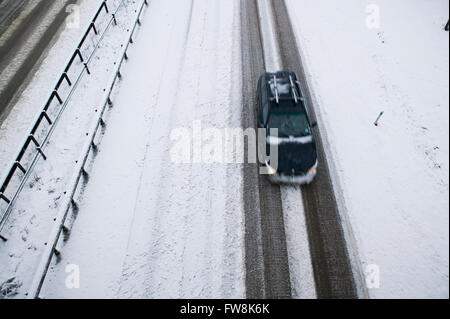 Una vista della A419 / A417 by pass la coperta di neve con i veicoli che viaggiano molto lentamente nella pericolosa condizioni stradali, nella foto dopo un pesante nevicata invernale la strada che teste attraverso il cuore di Cotswolds nel Regno Unito è a malapena praticabile in questi unusally cattive condizioni per viaggiare. Foto Stock