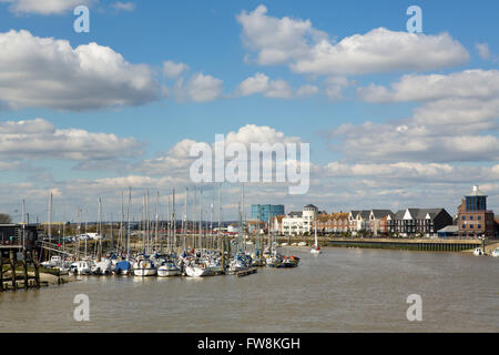 Vista guardando fino al fiume Arun a Littlehampton dove il fiume incontra il mare. Giornata di Primavera con il cielo blu e nuvole soffici Foto Stock