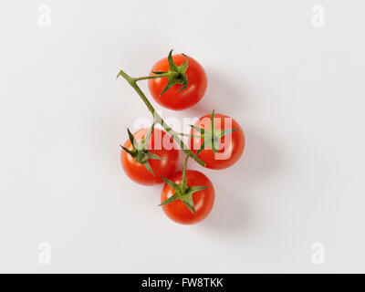 Quattro pomodori ciliegia sulla vite Foto Stock