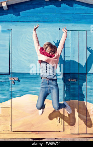 Giovane donna jump e ascoltare musica con le cuffie. Foto Stock