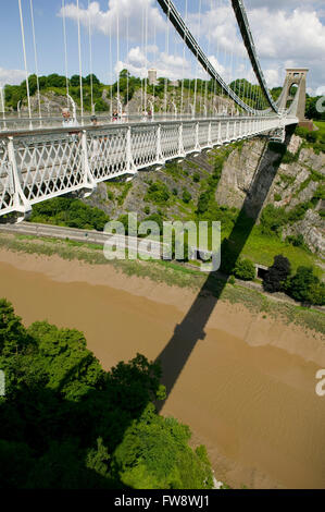 Persone attraversando a piedi sopra il ponte sospeso di Clifton, Clifton, Bristol, Regno Unito. Costruito acquistare il famoso ingegnere civile Isambard Kingdom Brunel il ponte attraversa il fiume Avon alcuni 200 piedi al di sotto ed è visto qui in un disegno astratto come il ponte e dei suoi fili di sospensione sono mirroed sul fango e il fiume sottostante mediante i ponti ombra creando un immagine grpahic. Foto Stock