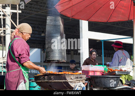 Un cibo di strada fornitore su Dan Singkhon mercato, nei pressi del confine Thai-Myanmar (Thailandia). Cuisinier de rue, un jour de Marché. Foto Stock