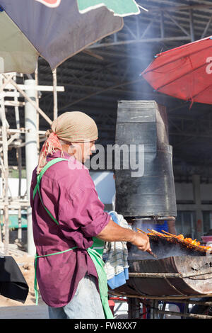 Un cibo di strada fornitore su Dan Singkhon mercato, nei pressi del confine Thai-Myanmar (Thailandia). Cuisinier de rue, un jour de Marché. Foto Stock