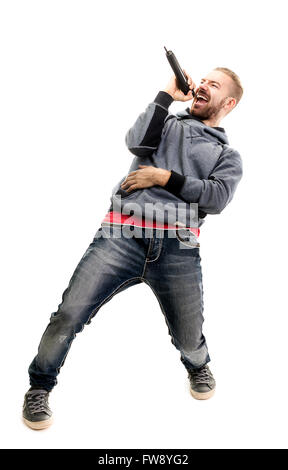 Ritratto in studio di un uomo cantano con microfono isolati su sfondo bianco, un bel giovane con capelli biondi cantando con dri Foto Stock