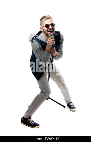 Giovane uomo cantano con microfono isolati su sfondo bianco, moderno superstar Foto Stock