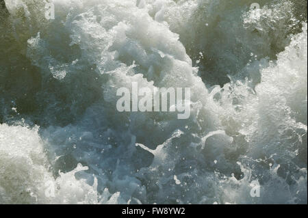 Acqua zangolatura e gorgogliamento con energia come cade da una serratura e weir sistema su un fiume nel Regno Unito. Foto Stock