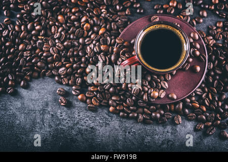 Il caffè. Tazza di caffè nero e schizzi di caffè in grani. Pausa caffè. Foto Stock