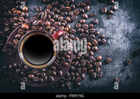 Il caffè. Tazza di caffè nero e schizzi di caffè in grani. Pausa caffè. Foto Stock