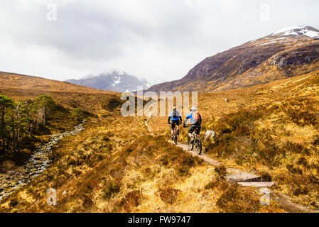 Gli amanti della mountain bike su sopra Moorland Glen Coulin in Torridon Highland scozzesi. Beinn Liath Mhor sulla destra e Fuar Tholl nella nebbia Foto Stock