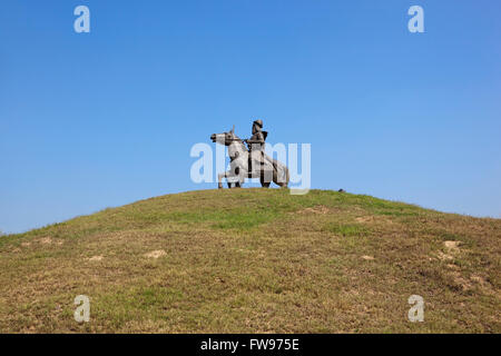 Una statua di uno dei Baba Banda Singh Bahadurs generali su una collinetta erbosa sotto un cielo blu Foto Stock