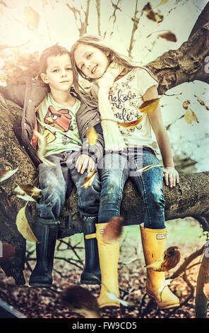 Fratello e Sorella seduta su albero Foto Stock
