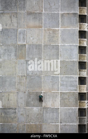 Il steeplejack su un muro di cemento di un sotto casa di costruzione Foto Stock