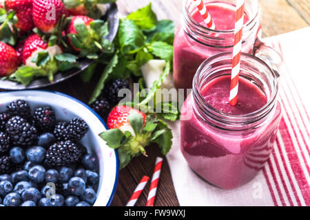 Benessere e perdita di peso concetto, berry smoothie.sul tavolo di legno con ingredienti, dal di sopra. Foto Stock