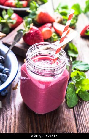 Benessere e perdita di peso concetto, berry smoothie.sul tavolo di legno con ingredienti, dal di sopra. Foto Stock