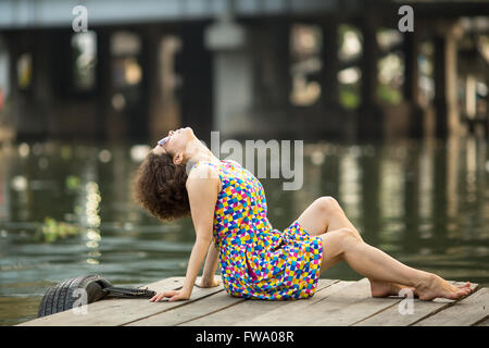 Bella donna asiatica in occhiali da sole in legno argine del fiume. Foto Stock