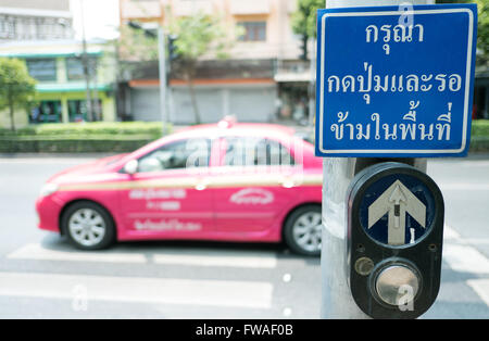 Premere il pulsante per il semaforo rosso in Thailandia. lingua thai -- (messa a fuoco selettiva) Foto Stock