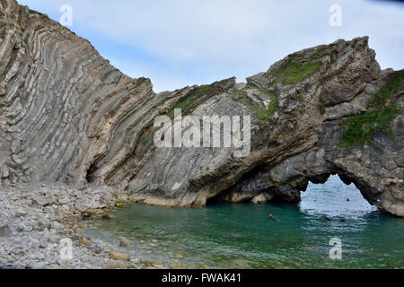 Incredibile la geologia del foro di scale su Jurassic Coast, con arch. Un accartocciamento in rocce in Dorset, che mostrano la direzione della piega. Foto Stock