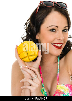 Sano giovane donna in possesso di un pezzo di mango fruit isolata contro uno sfondo bianco Foto Stock