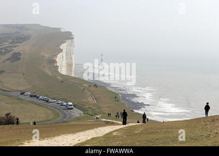 Beachy Head, East Sussex. Inghilterra, Regno Unito. Il 2 aprile 2016. In una bella giornata sulla costa del Sussex, molti escursionisti sono voce per Beachy Head dove il faro è appena visibile nella foschia sotto le scogliere di gesso. Credito: Julia Gavin UK/Alamy Live News Foto Stock