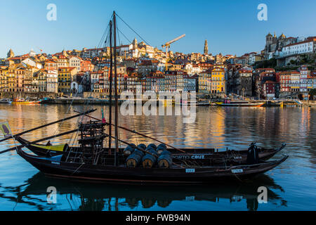 Tradizionale barca Rabelo progettati per trasportare il vino verso il basso lungo il fiume Douro con lo skyline della citta' dietro, Porto, Portogallo Foto Stock